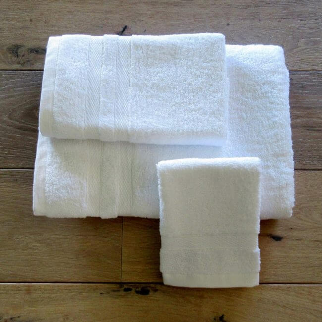 Moyan 100% Cotton Towels with double-stitched edges and decorative borders, available as bath towels, hand towels, washcloths, and bath mats, perfect for hotels, spas, and resorts